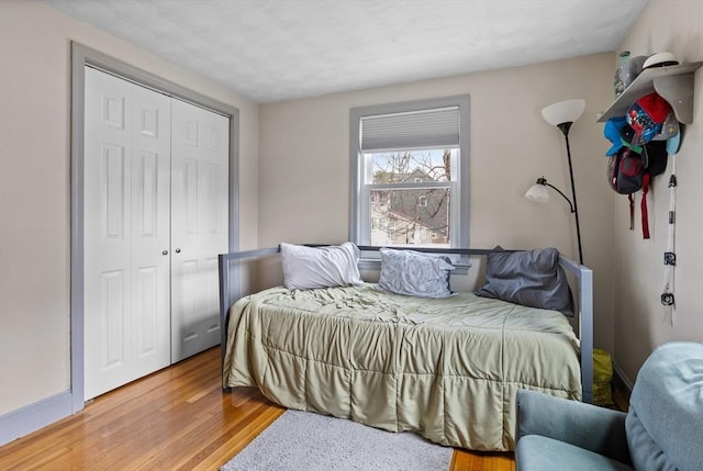 bedroom with light wood-type flooring and a closet