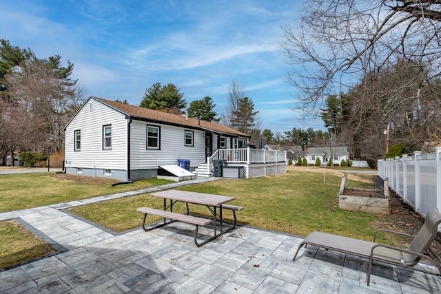 back of house with a vegetable garden, a yard, a patio, and a wooden deck