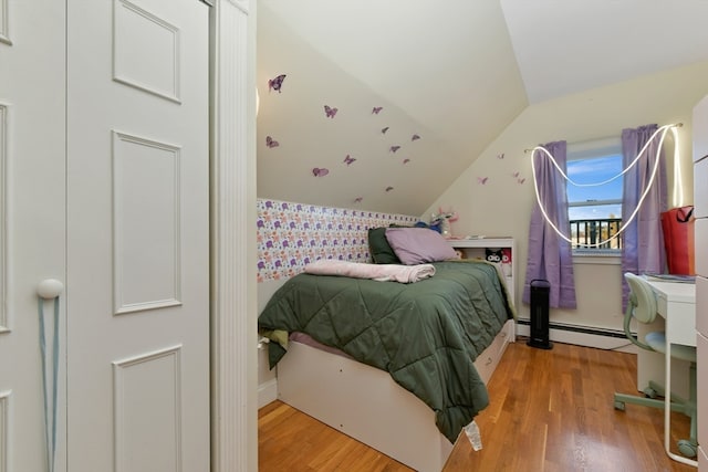 bedroom with hardwood / wood-style floors, a baseboard radiator, and vaulted ceiling