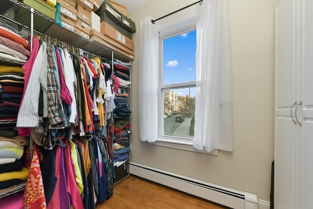 walk in closet featuring wood-type flooring and a baseboard radiator