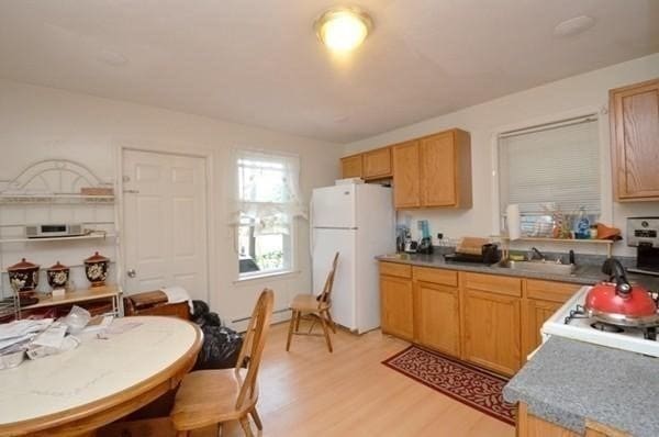 kitchen featuring white fridge, light hardwood / wood-style floors, and sink