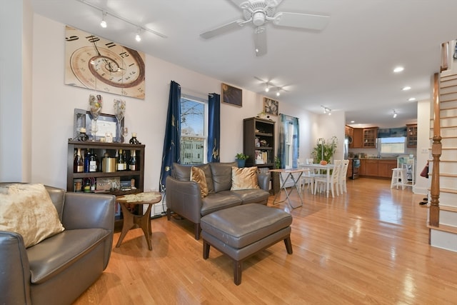 living room featuring ceiling fan, track lighting, and light wood-type flooring