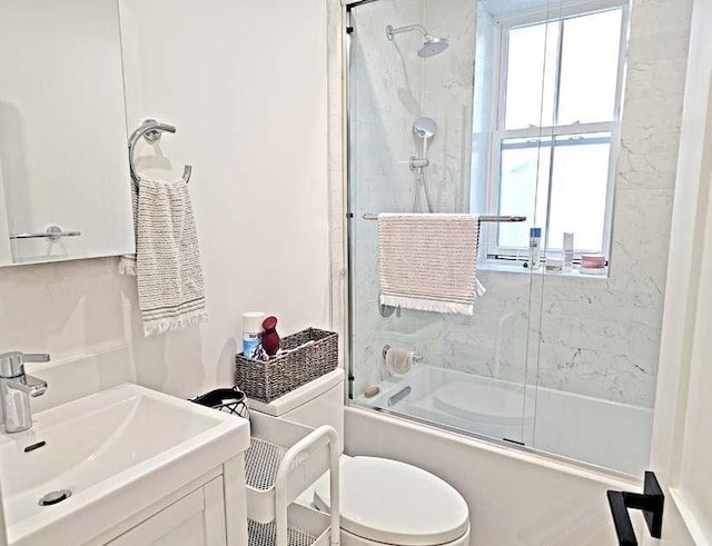 full bathroom with bath / shower combo with glass door, vanity, and toilet