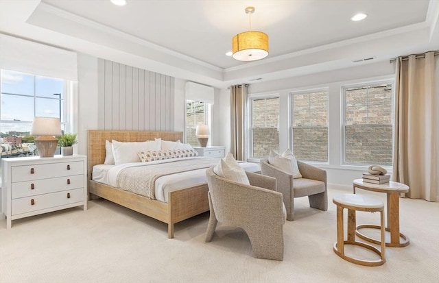 bedroom with ornamental molding, light carpet, and a tray ceiling