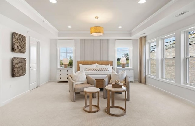 bedroom featuring ornamental molding, light colored carpet, and a tray ceiling