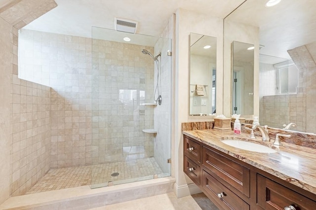 bathroom with vanity, visible vents, and a stall shower