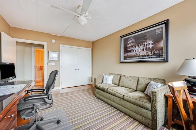 carpeted home office featuring ceiling fan