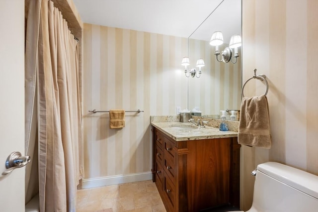full bath featuring a shower with curtain, vanity, baseboards, toilet, and wallpapered walls