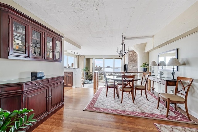 dining area with light wood-style floors, a chandelier, and a wealth of natural light