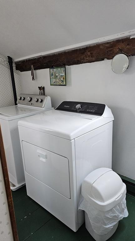 clothes washing area featuring separate washer and dryer and dark tile patterned floors