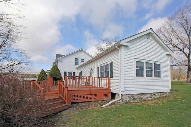 rear view of house featuring a deck and a lawn