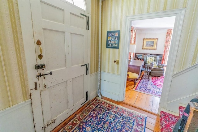 entrance foyer featuring a wainscoted wall and hardwood / wood-style floors