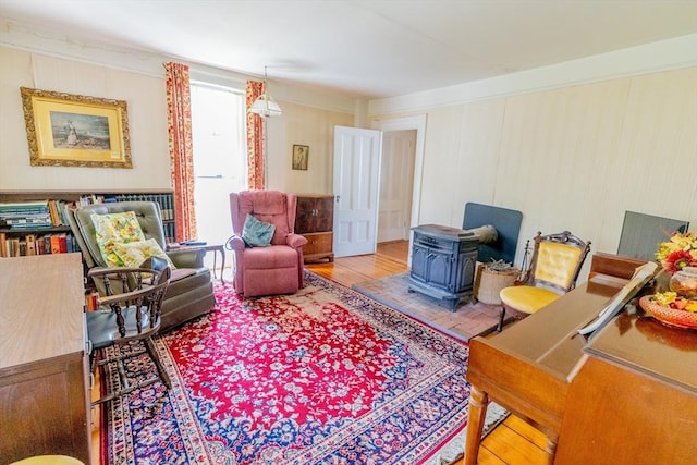 sitting room with a wood stove and wood finished floors