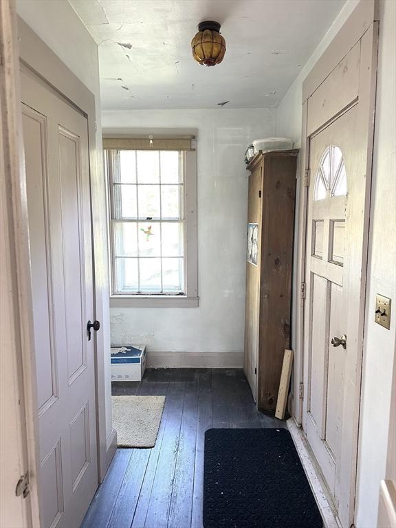 doorway to outside with wood-type flooring and baseboards