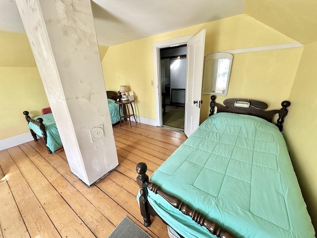 bedroom featuring light wood-style flooring and lofted ceiling