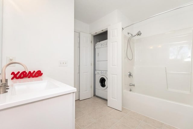 bathroom featuring vanity, tile patterned floors, washtub / shower combination, and stacked washer / drying machine