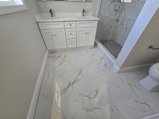 bathroom featuring a sink, baseboards, a shower stall, and marble finish floor