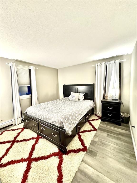 bedroom featuring light hardwood / wood-style floors and a textured ceiling