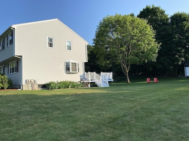 view of side of home featuring a lawn and a wooden deck