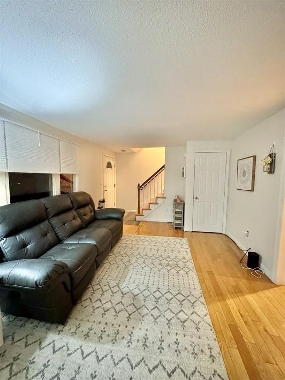 living room with wood-type flooring and a textured ceiling