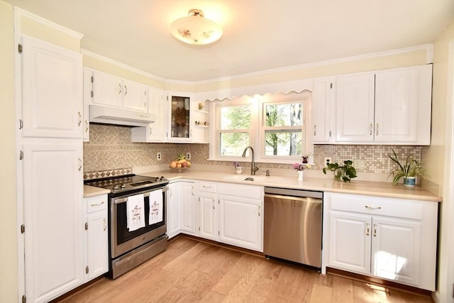 kitchen featuring a sink, light wood finished floors, stainless steel appliances, white cabinetry, and under cabinet range hood