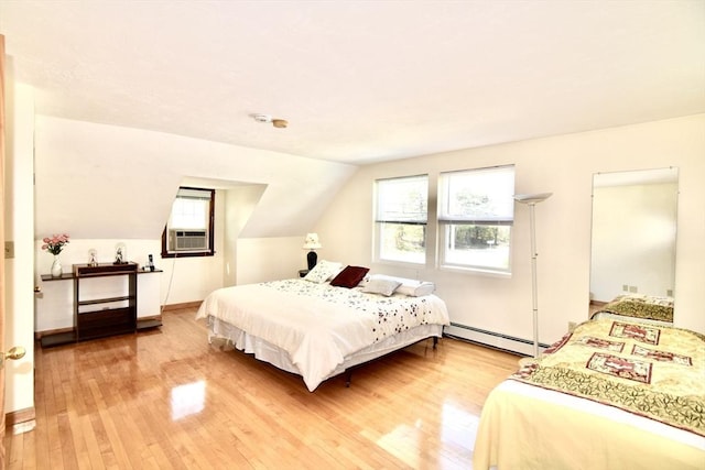 bedroom with vaulted ceiling, a baseboard radiator, multiple windows, and light wood-type flooring