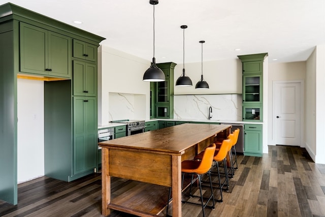 kitchen with green cabinetry, tasteful backsplash, dark wood-type flooring, sink, and pendant lighting