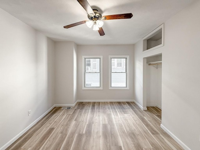 unfurnished bedroom with baseboards, a ceiling fan, light wood-style flooring, and visible vents