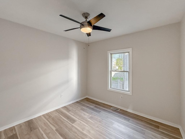 unfurnished room with baseboards, a ceiling fan, light wood finished floors, and visible vents