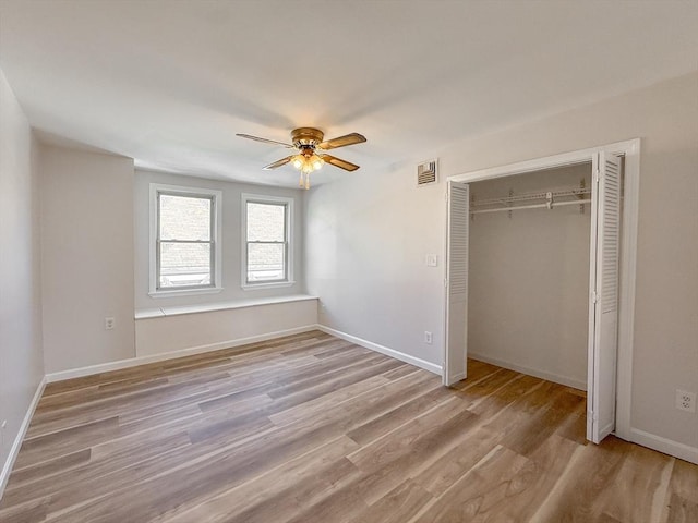 unfurnished bedroom with baseboards, visible vents, light wood-style flooring, and a closet