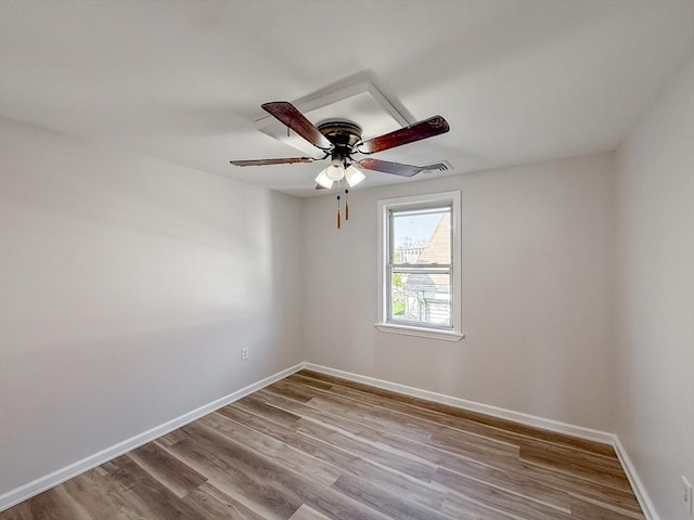 unfurnished room with baseboards, a ceiling fan, wood finished floors, and visible vents