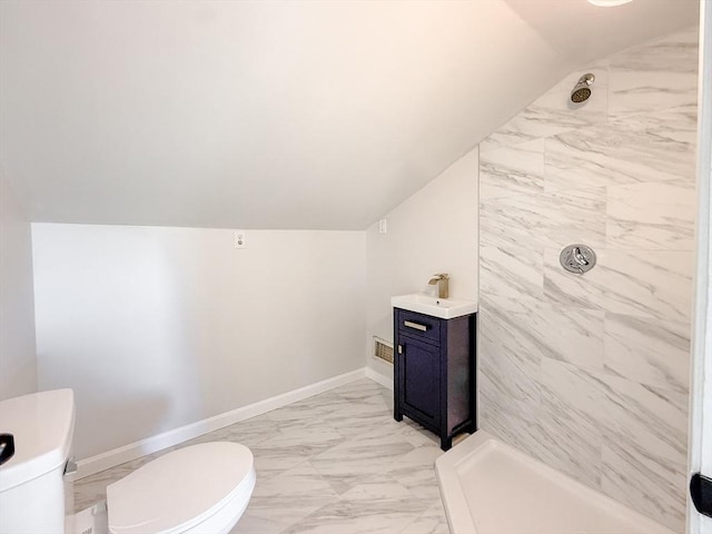 full bathroom featuring marble finish floor, lofted ceiling, toilet, a sink, and a tile shower