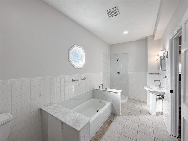 bathroom with visible vents, a garden tub, tile patterned flooring, tile walls, and a walk in shower
