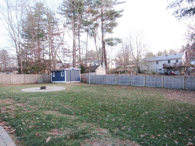 view of yard featuring a storage shed and an outdoor fire pit