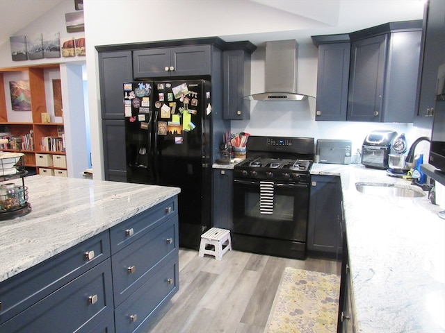 kitchen with sink, wall chimney exhaust hood, light hardwood / wood-style floors, lofted ceiling, and black appliances