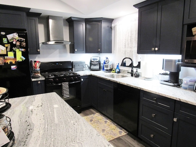 kitchen with sink, wall chimney exhaust hood, black appliances, and light wood-type flooring