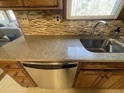 4 Fernandez Cir, Randolph, MA 02368 - kitchen featuring dishwasher, a sink, tasteful backsplash, brown cabinets, and light stone counters