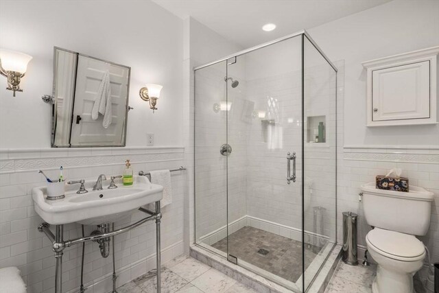 bathroom featuring toilet, an enclosed shower, and tile walls