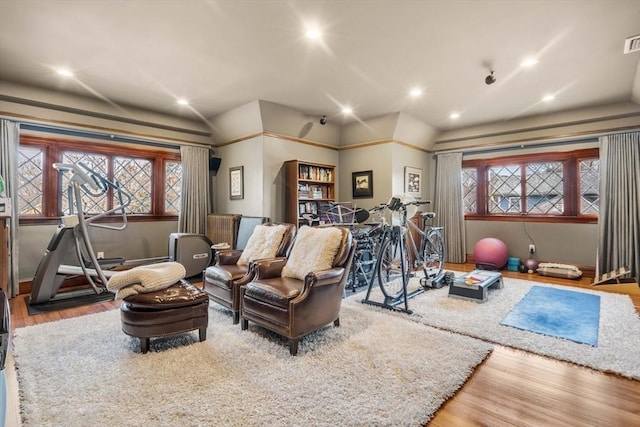 exercise room with hardwood / wood-style flooring and lofted ceiling