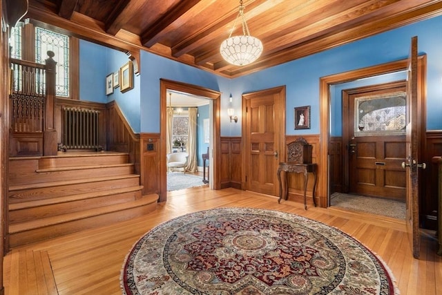 entrance foyer with a healthy amount of sunlight, radiator heating unit, wood ceiling, and light hardwood / wood-style flooring