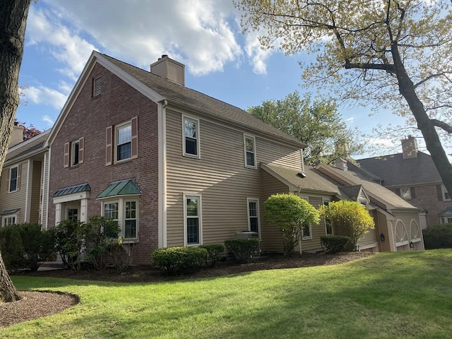 view of property exterior featuring a chimney, a yard, and brick siding