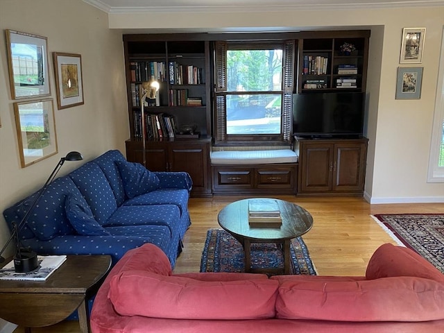 living area with crown molding, light wood-style floors, plenty of natural light, and baseboards
