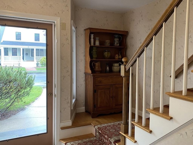 foyer entrance with stairway, plenty of natural light, wallpapered walls, and light wood finished floors