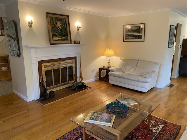 living room featuring ornamental molding, wood finished floors, a tile fireplace, and baseboards