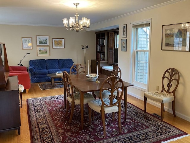 dining space with a chandelier, crown molding, light wood-style flooring, and baseboards