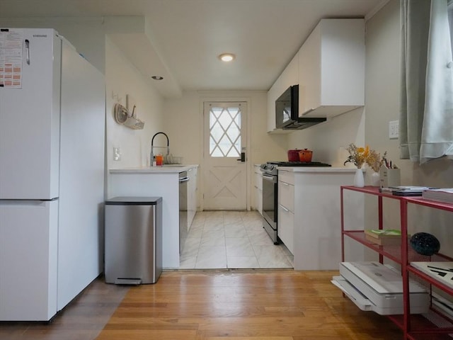 347 Lexington St, Woburn, MA 01801 - kitchen with stainless steel appliances, white cabinets, recessed lighting, a sink, and light wood finished floors