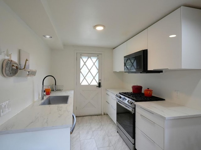 347 Lexington St, Woburn, MA 01801 - kitchen with stainless steel gas stove, a sink, light marble finish floors, black microwave, and white cabinets