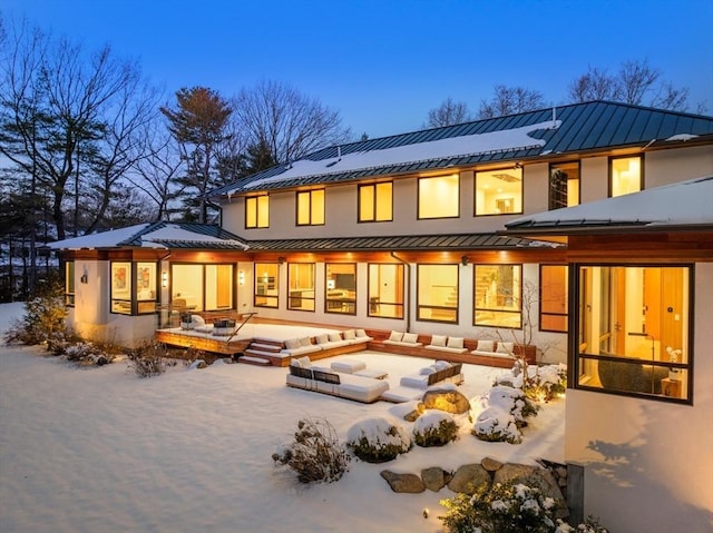 snow covered back of property featuring a patio and solar panels