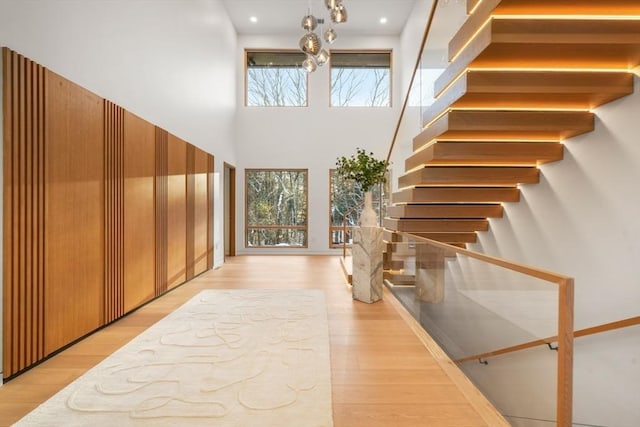 interior space featuring a towering ceiling and light hardwood / wood-style floors