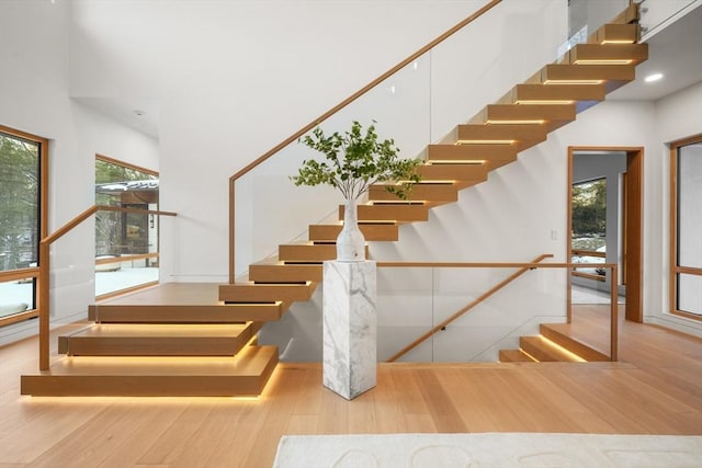 staircase with a high ceiling and hardwood / wood-style floors